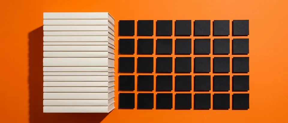 A stack of books turning into a grid of paper squares, standing for AI training data