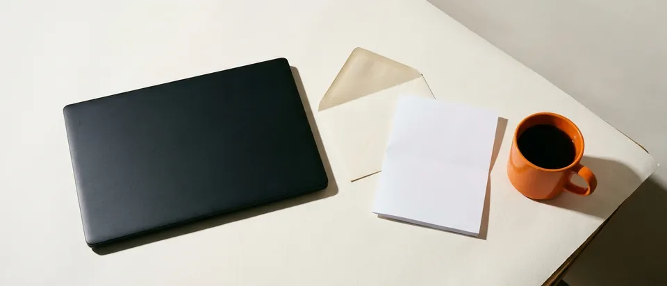 A laptop and an opened letter on a kitchen table