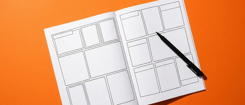 An open comic book with blank and inked panels on an orange background